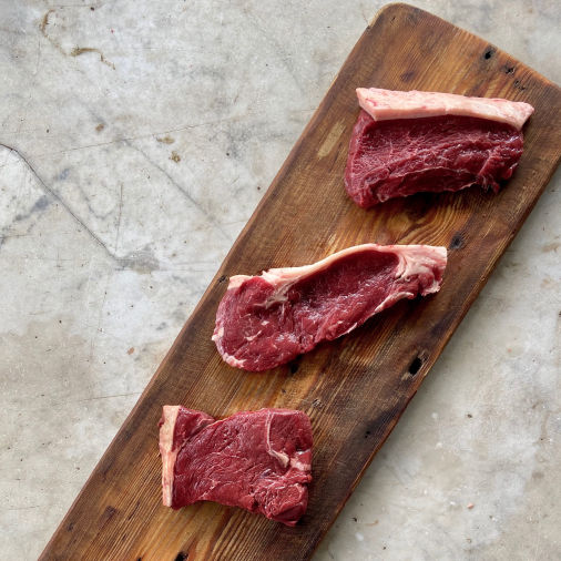 Fillet, sirloin and rump steak on wood platter 